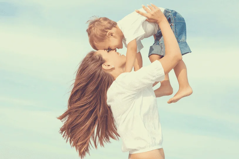 mommy holding toddler son in air