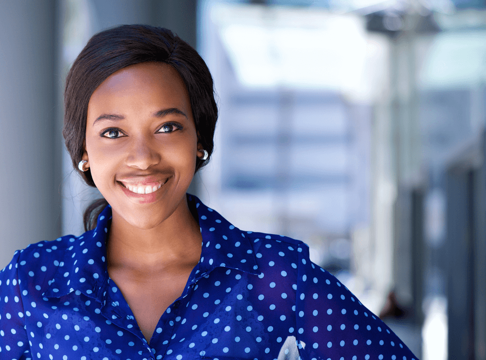 image of a young woman of color in a blue shirt with white polka dots