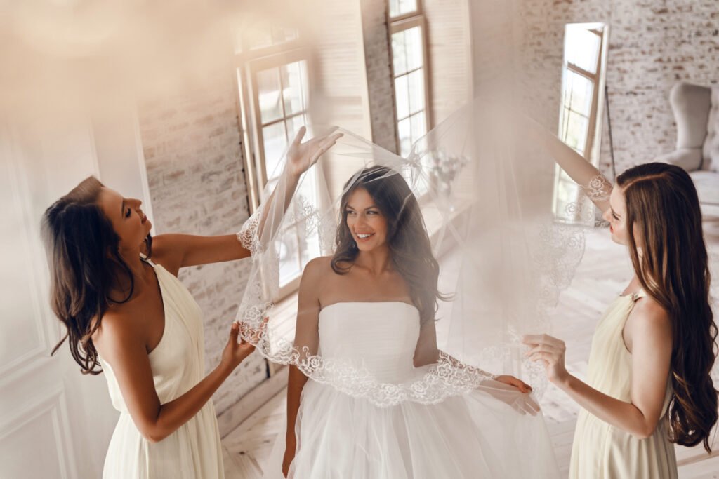 Happy Bride Trying on Wedding Dresses with her Bridesmaids