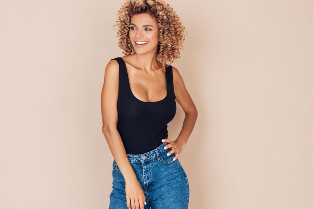 Happy healthy woman in jeans with tank top