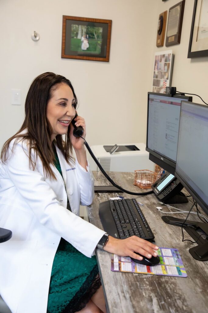 Dr. Katerina Gallus on phone with patient in her office