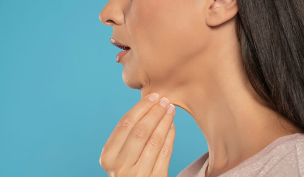 Close up profile view of woman pinching extra skin on neck