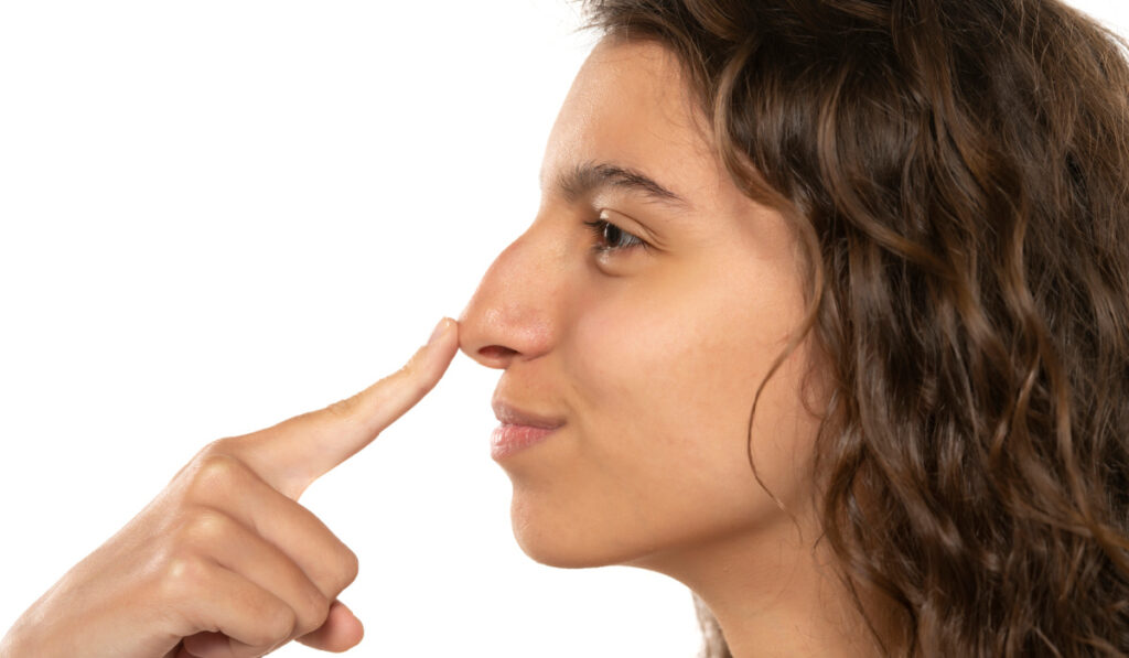 Woman smiling and touching her nose