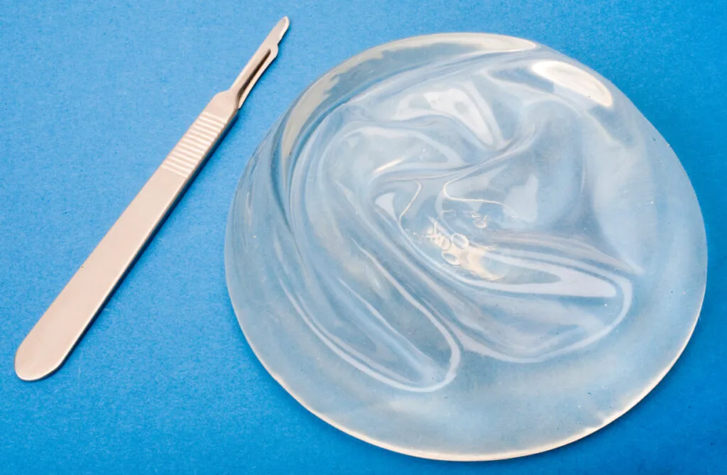 Silicone breast implant on table with scalpel